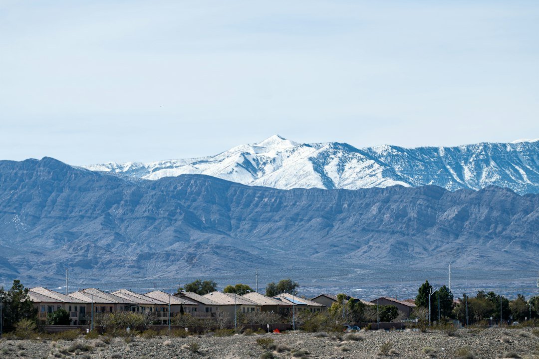 Snow-capped mountains rise behind a row of houses